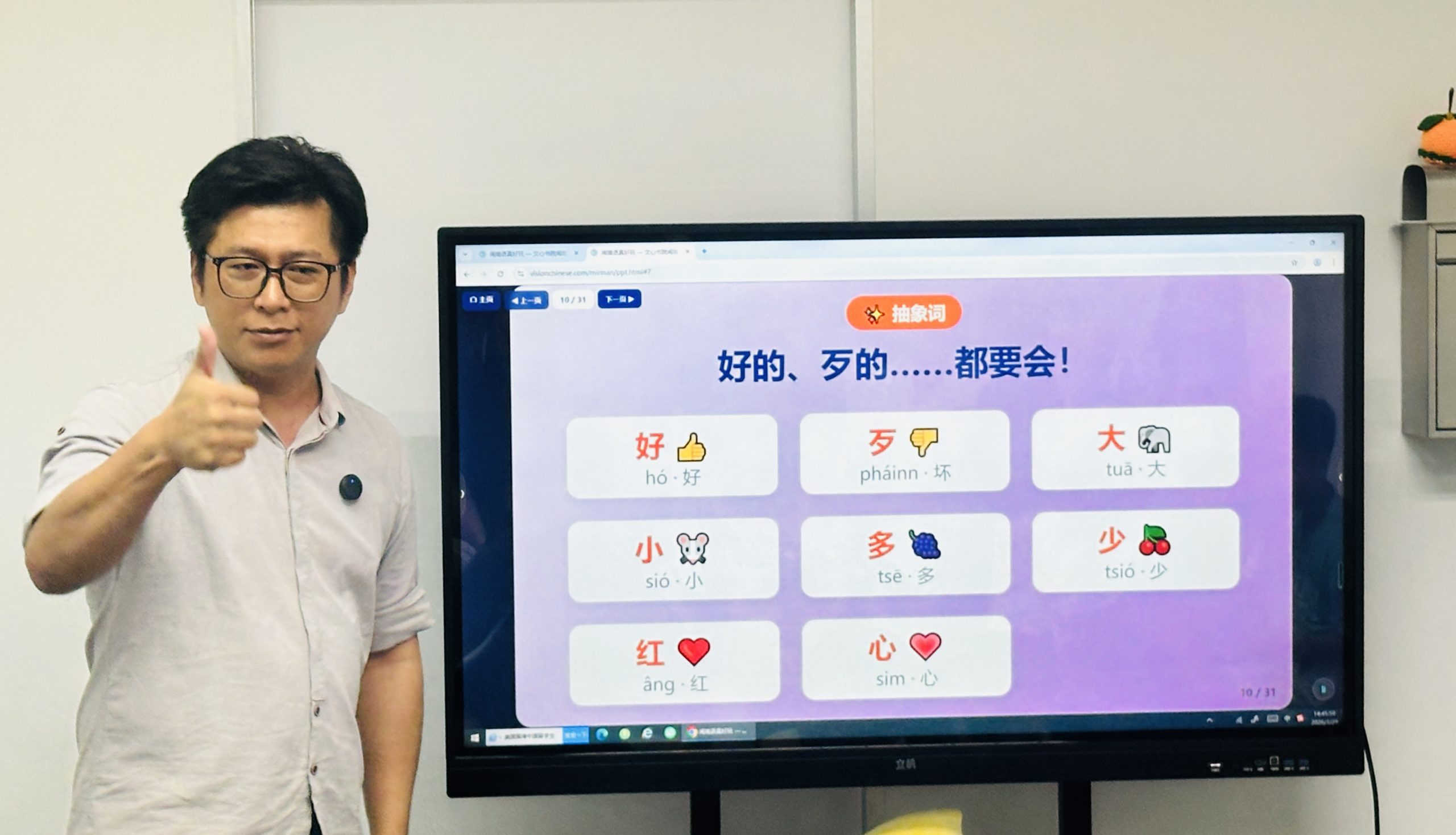 朱海滨老师在屏幕前讲解闽南语词汇，做出点赞手势